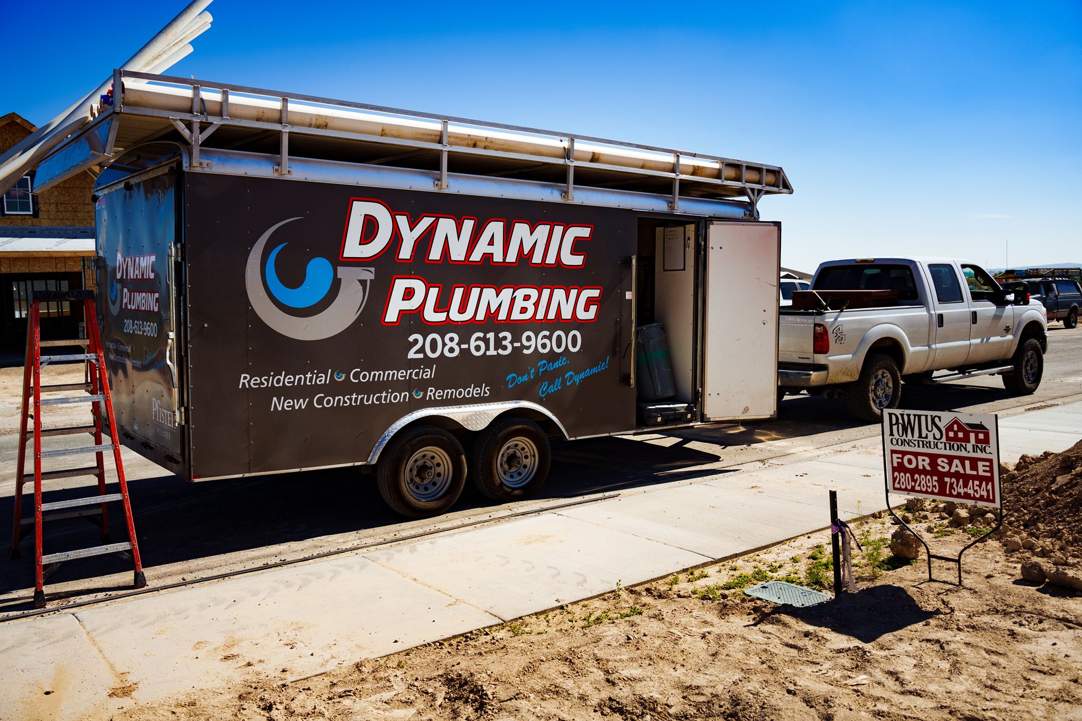 Dynamic Plumbing Trailer and truck outside of a job site